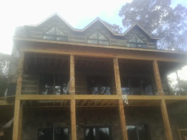 Dormers and porch framing on a large log home under construction — Roof Coating work by our crew in Mauldin