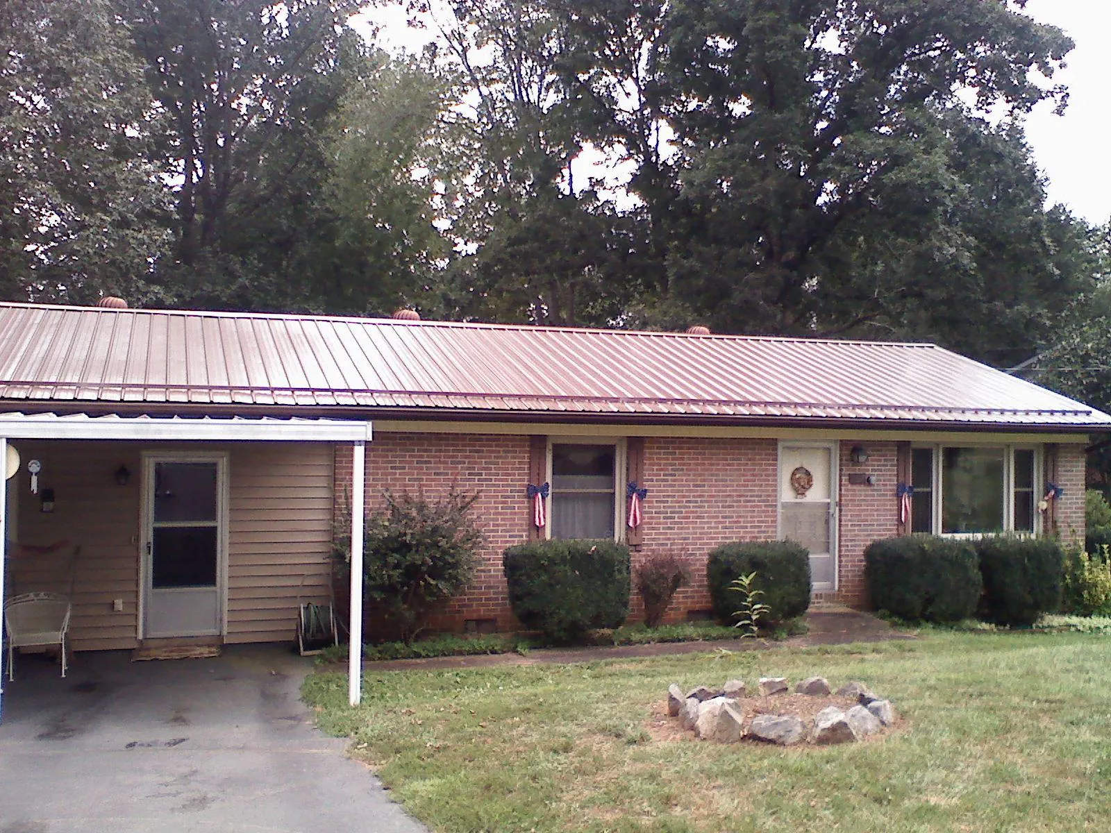 Bronze metal roof and carport on a brick ranch home — Roof Repair work by our crew in Mauldin