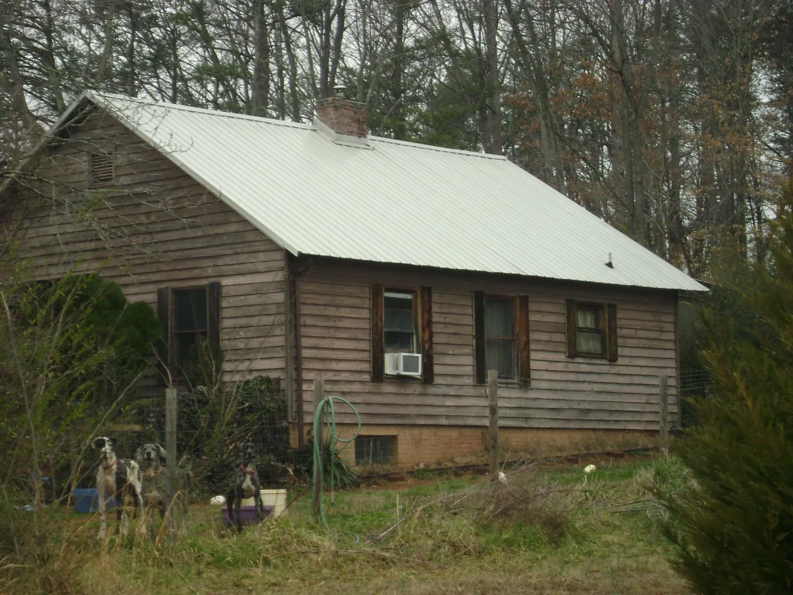 White metal roof on an old wood sided farmhouse, from a Asphalt Shingle Roof Repair job in Mauldin